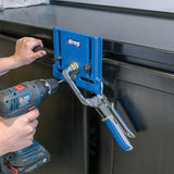 Person using a drill and a blue pocket hole jig clamped to a cabinet door