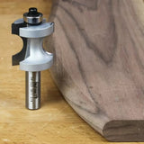 Roundover router bit next to shaped wooden board on workbench