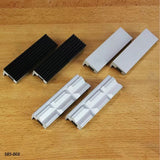 Set of aluminum and rubber woodworking vise jaw pads on a wooden surface