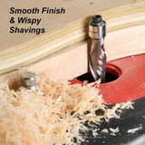 Spiral router bit cutting plywood on router table with fine wood shavings and smooth finish.