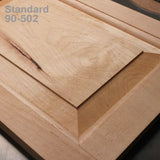 Close-up of a wooden cabinet door panel with beveled edges and light wood grain texture