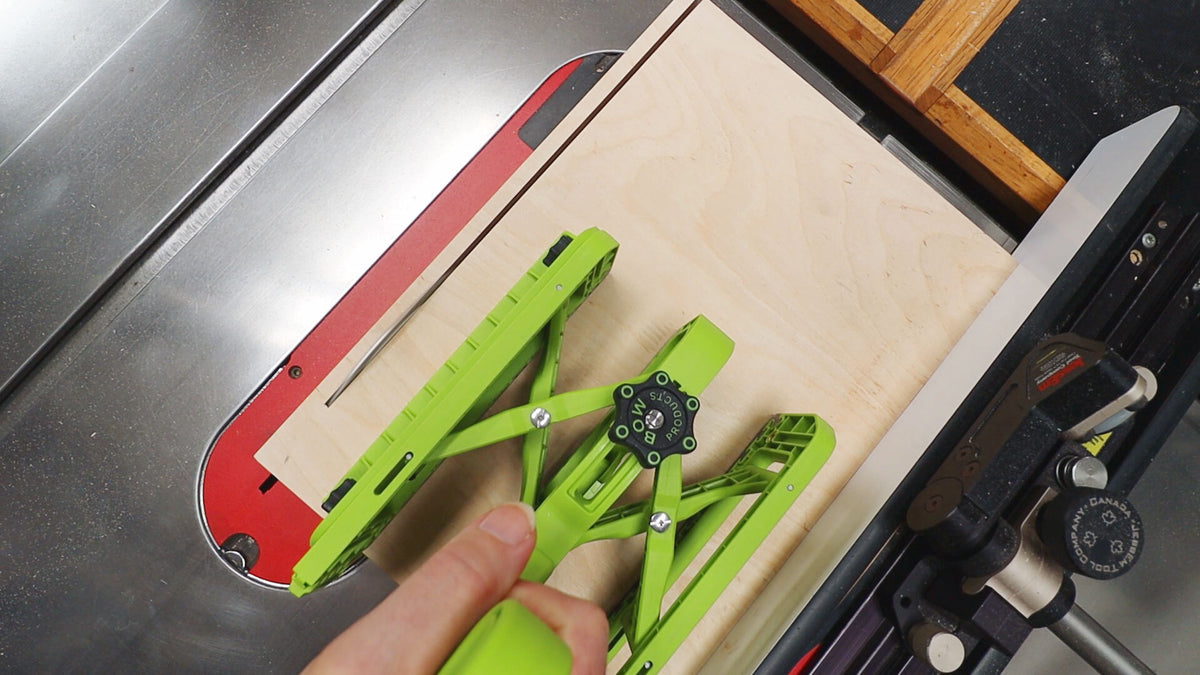 Green metal frame being adjusted on a table saw