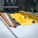 Woodworking table saw setup with yellow featherboard and hardwood strips