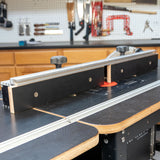 MDF router table fence installed on a router table in a woodworking shop setting.