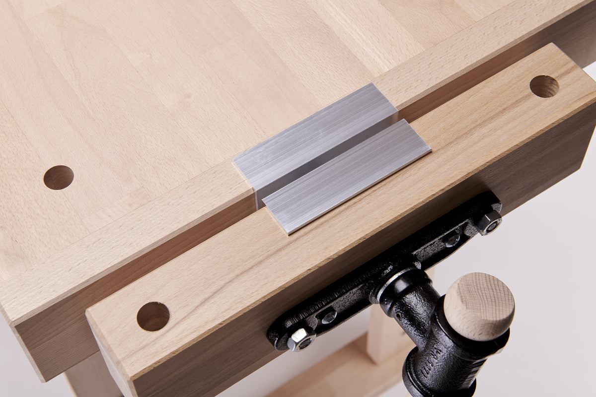 Wooden work bench clamp with metal jaw covers installed.