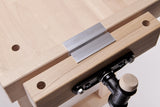 Wooden work bench clamp with metal jaw covers installed.