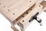 Close-up of a light natural wood workbench with a clamp, showing the wood grain, and a black-and-white crank handle on a white background.