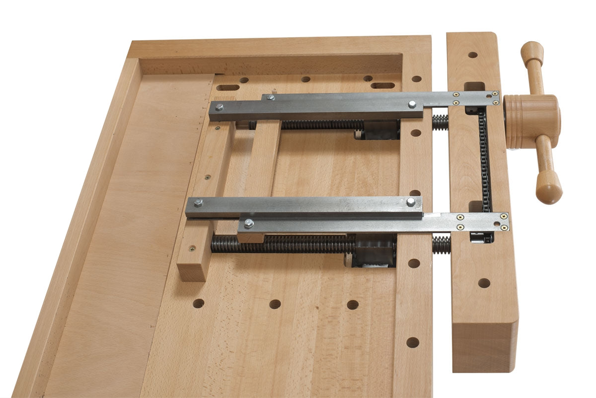 A wooden workbench clamp with a light natural wood body, silver metal guide bars, black threaded screws, and a wooden handwheel, shown on a plain white background.