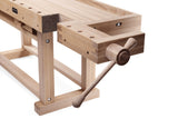 Close-up of a wooden workbench vise with a crank handle, made from light natural wood with darker brown accents, on a white background.