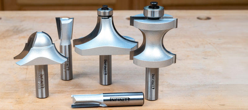 Set of metal router bits on a wooden surface