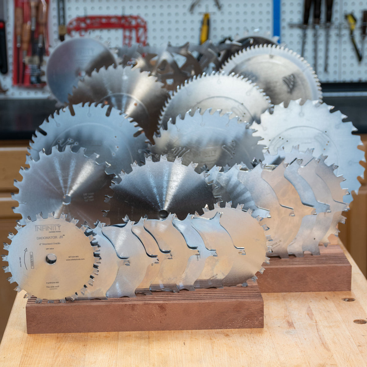 Collection of circular saw blades on a wooden stand in a workshop setting
