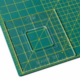 Acrylic square quilting ruler template on a green gridded cutting mat, marked with measurements.