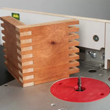 Box joint woodworking project on router table with router bit and red insert plate