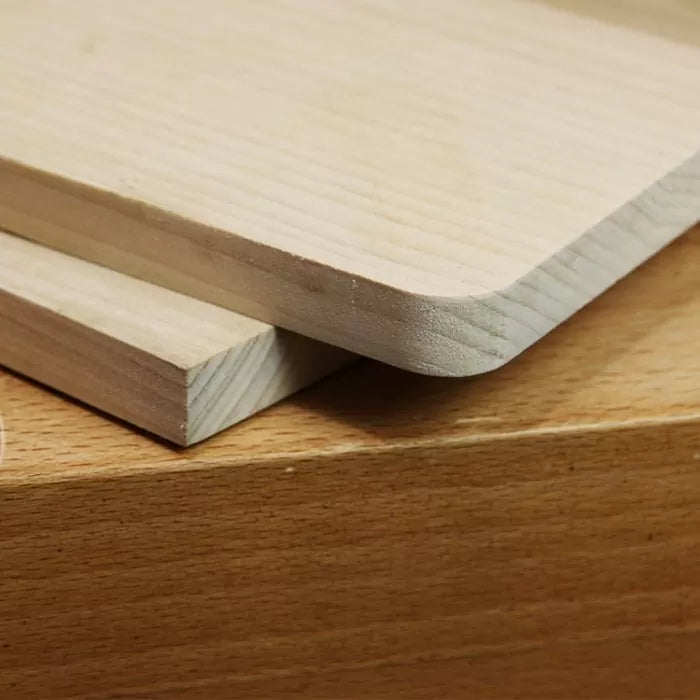 Close-up of wood boards with rounded and square edges, showcasing precise woodworking cuts