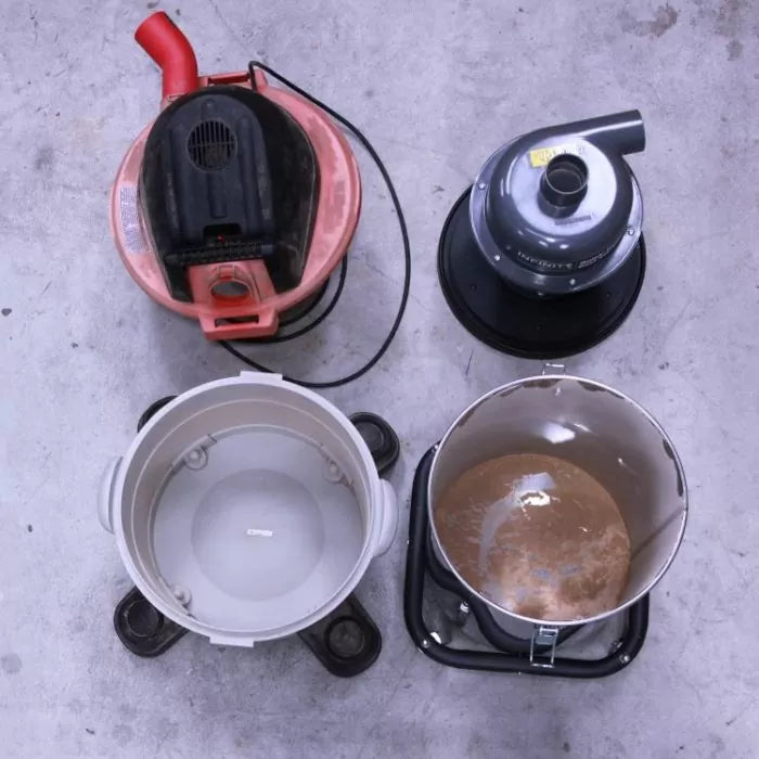 Overhead view of two dust collector lids and two dust collection bins on a workshop floor