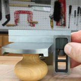 Woodworking plane with flat sole checked by precision square on workbench, pegboard tools behind