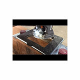 Woodworking router cutting wood with guide jig on workbench