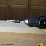 Drill with attached quick-change bit adapter for woodworking on a workshop table