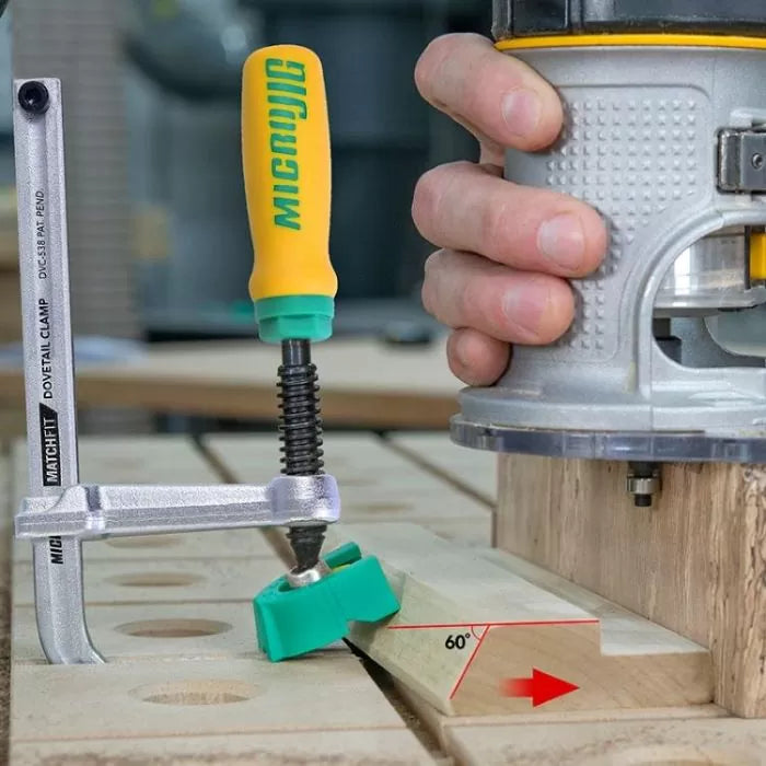 Hand using wood router and dovetail clamp on workbench for precise angled woodworking cut
