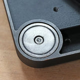 Close-up of a metal roller bearing mounted in a woodworking tool housing on wood surface