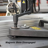 Close-up of a woodworking tool with magnetic base disengaged, lever handle shown on table saw.