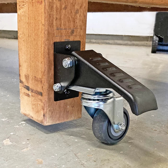 Workbench corner with installed locking caster wheel and foot lever on concrete floor
