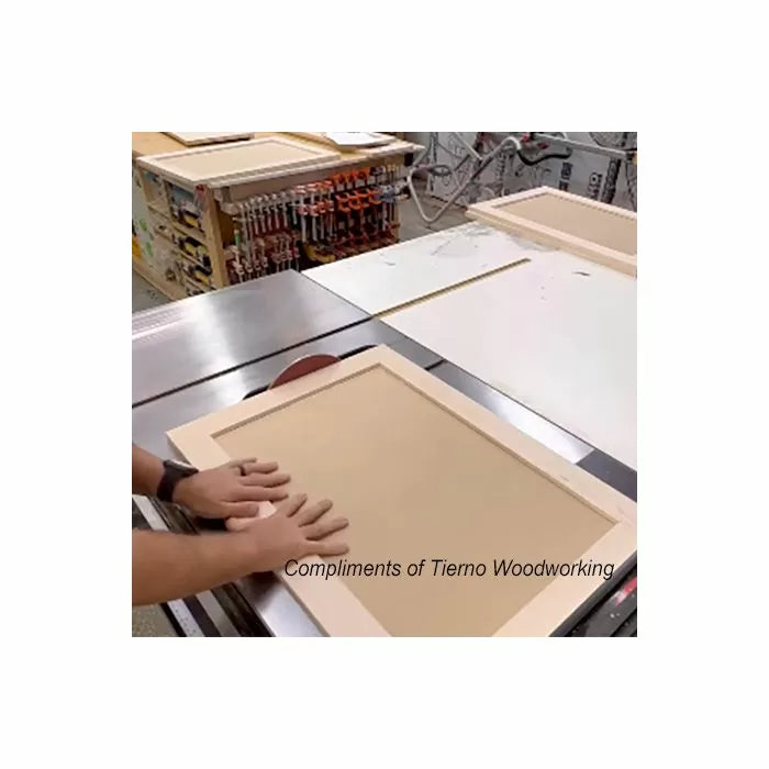Woodworker assembling a cabinet door panel on a workbench in a woodworking shop