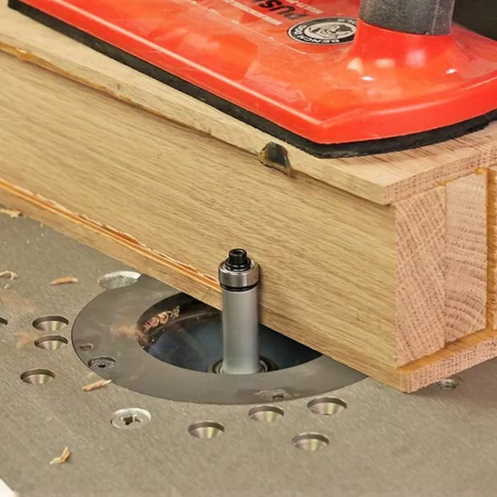 Straight router bit cutting wood on a router table for precision woodworking