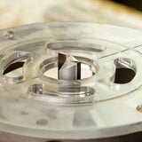 Close-up of straight router bit mounted in a router table for woodworking precision.